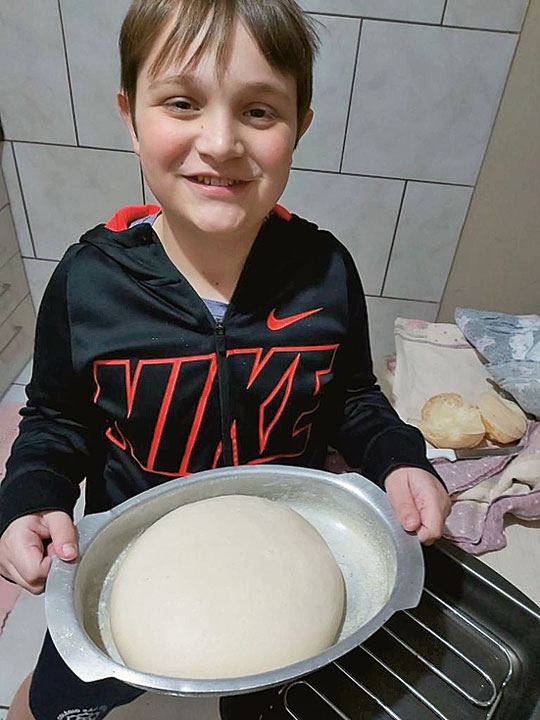 Menino vende pão e compra figurinhas